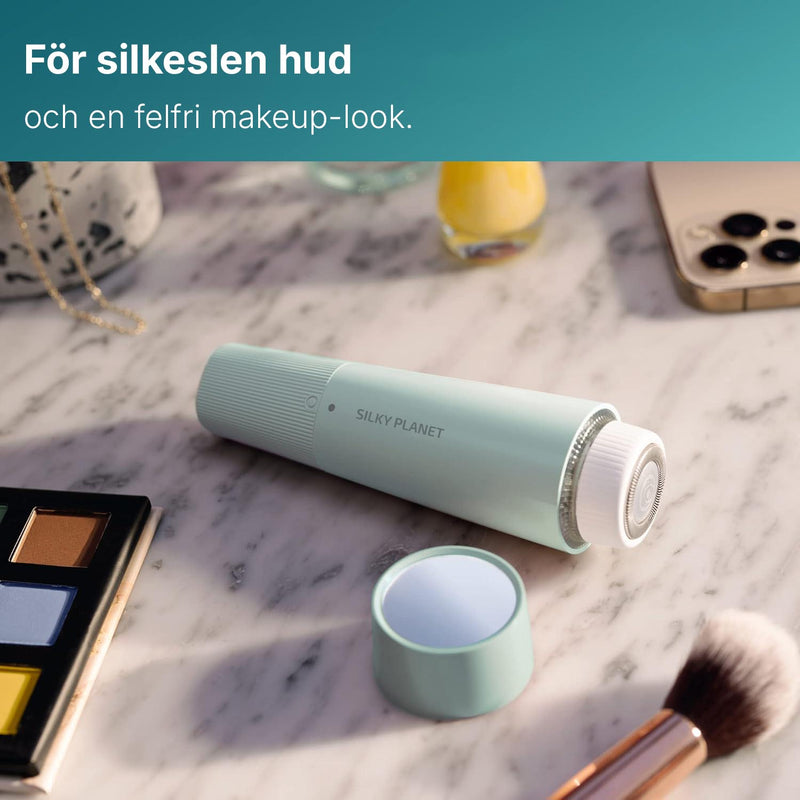 Silky Planet ansiktshårborttagare liggande på ett sminkbord bland smycken och sminkprodukter.