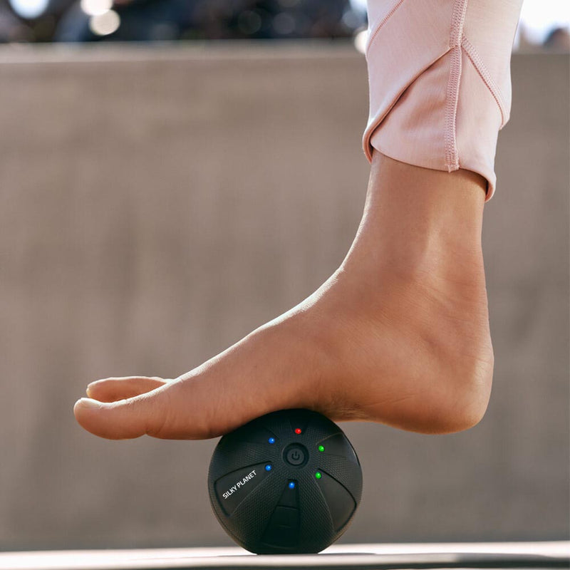 En fot vilar på Silky Planets massageboll för fotmassage.